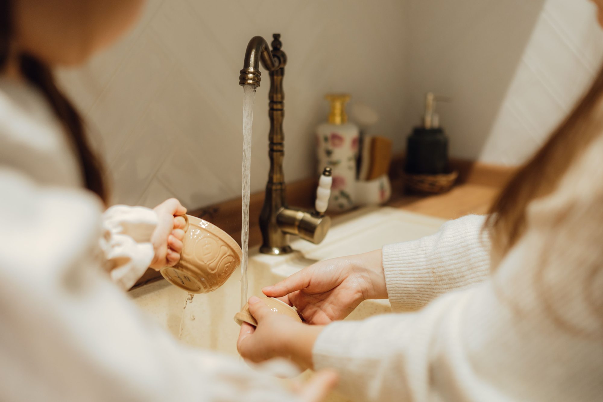 two people putting the hands uner running tap water